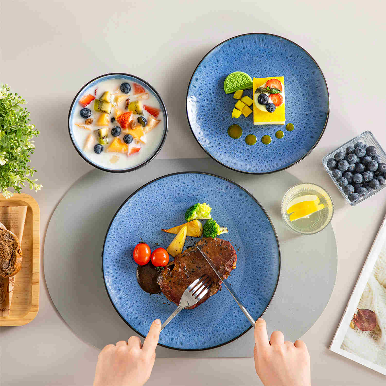 The Bubble 12-Piece Dinnerware Set features stoneware with a reactive glaze - offering farmhouse charm in blue plates and bowls - perfect for serving 4-vancasso