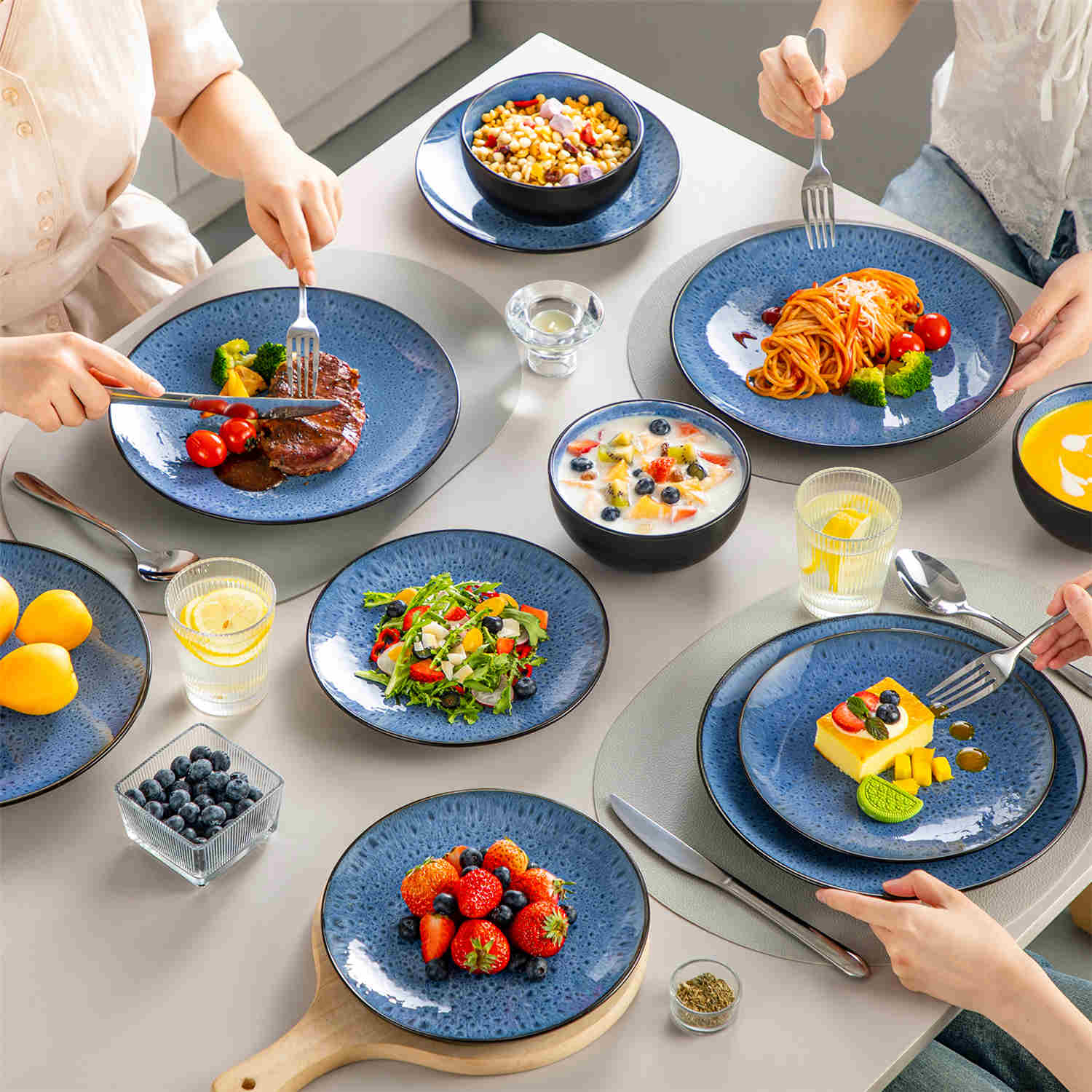 The Bubble 12-Piece Dinnerware Set features stoneware with a reactive glaze - offering farmhouse charm in blue plates and bowls - perfect for serving 4-vancasso