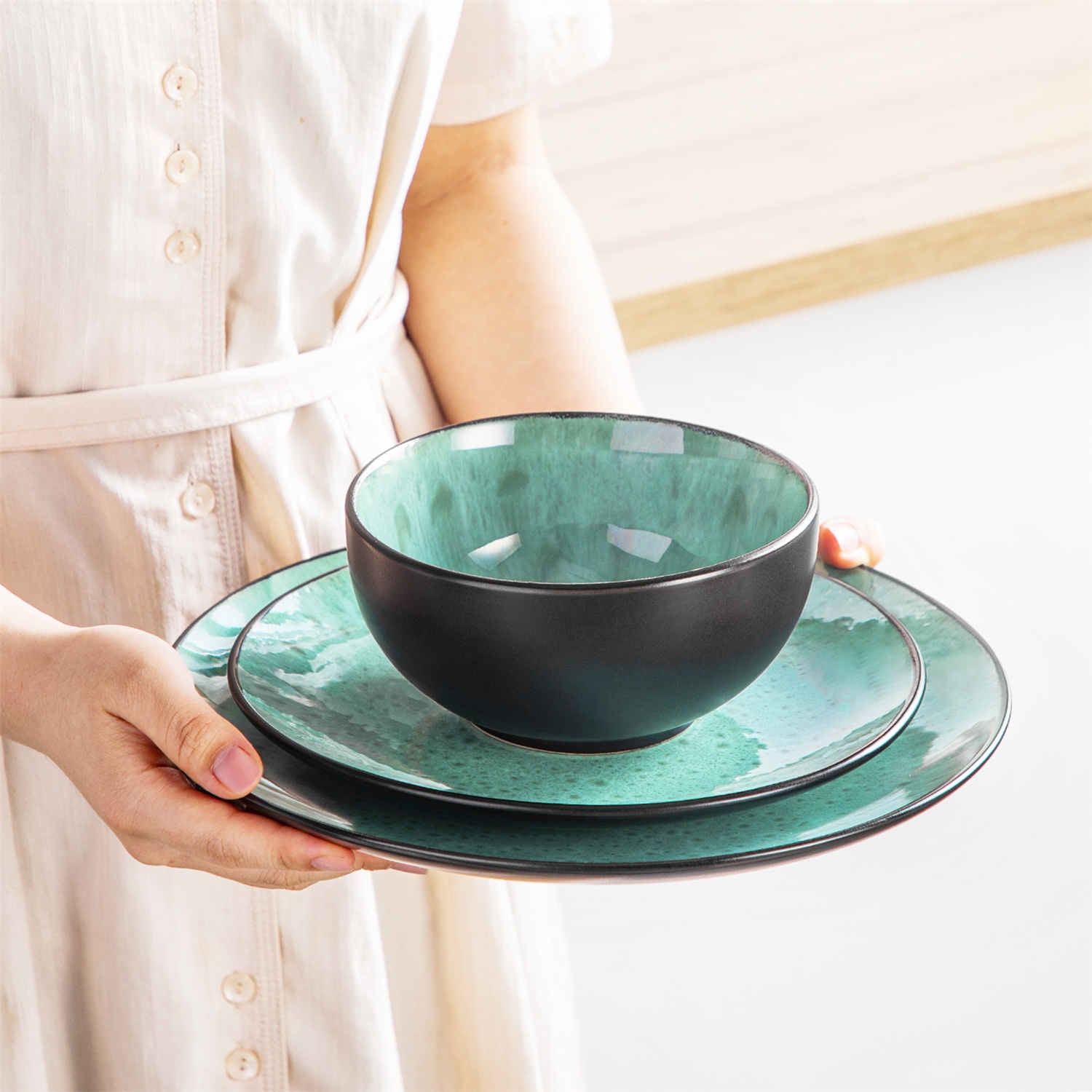 The Bubble 12-Piece Dinnerware Set features stoneware with a reactive glaze - offering farmhouse charm in green plates and bowls - perfect for serving 4-vancasso