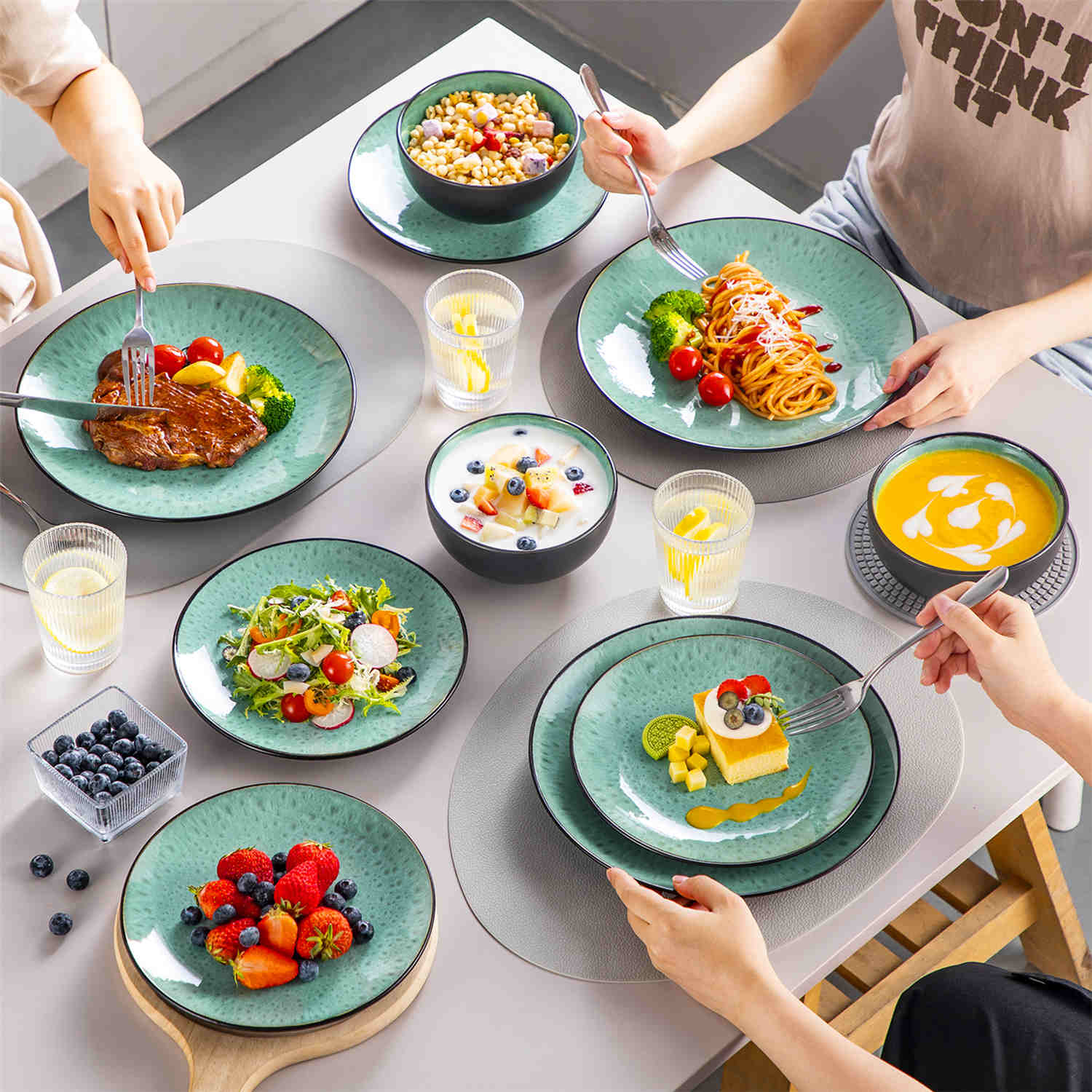 The Bubble 12-Piece Dinnerware Set features stoneware with a reactive glaze - offering farmhouse charm in green plates and bowls - perfect for serving 4-vancasso