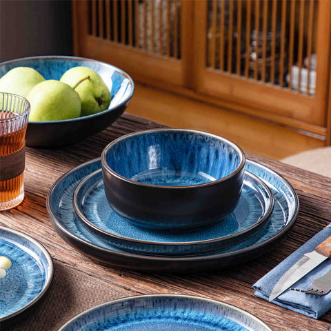 A glossy blue 16-piece stoneware dinnerware set from the Playa collection - featuring farmhouse charm with plates and bowls for 4 people-vancasso