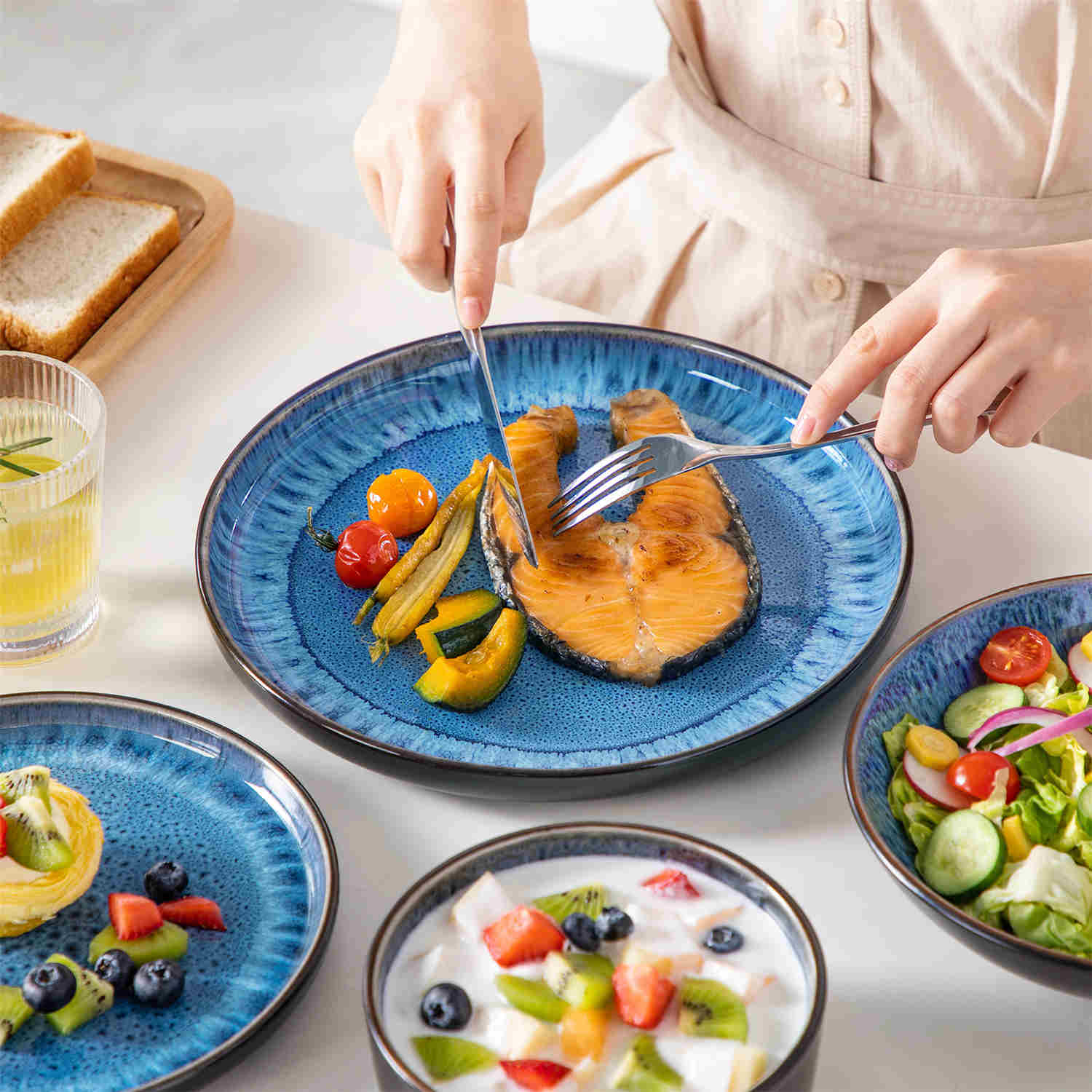 A glossy blue 24-piece stoneware dinnerware set from the Playa collection - featuring farmhouse charm with plates and bowls for 6 people-vancasso