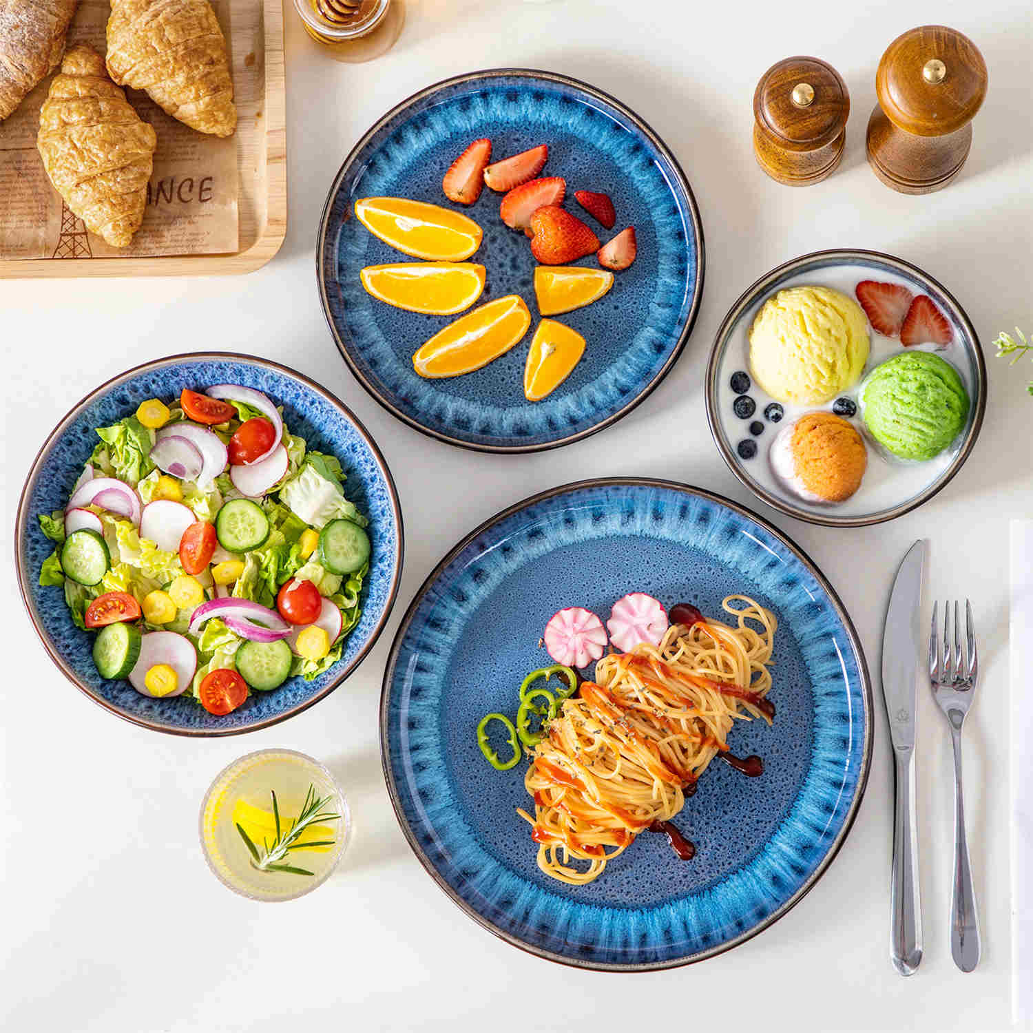 A glossy blue 24-piece stoneware dinnerware set from the Playa collection - featuring farmhouse charm with plates and bowls for 6 people-vancasso