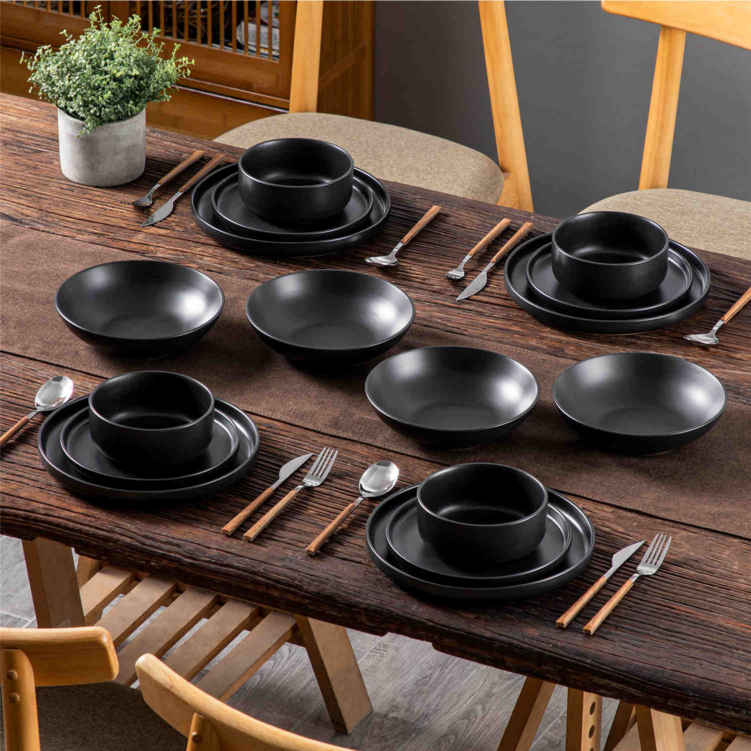 A matte black 16-piece stoneware dinnerware set from the Playa collection - offering a modern touch with plates and bowls for 4 people-vancasso.