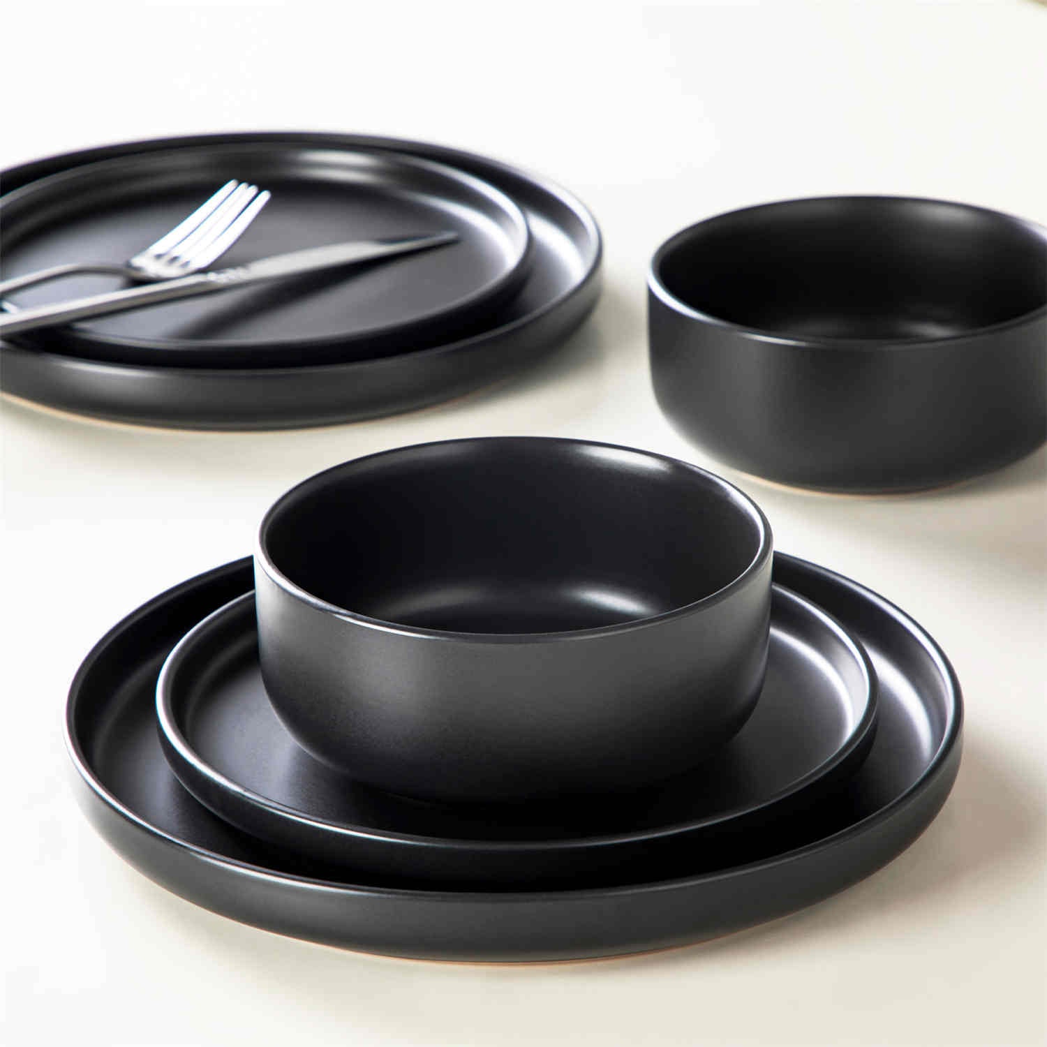 Playa 18-Piece Stoneware Dinnerware Set for 6, featuring plates and bowls in a modern Ibiza-inspired style with a matte black finish-vancasso