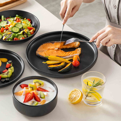 A matte black 24-piece stoneware dinnerware set from the Playa collection by vancasso - adding a modern flair with plates and bowls for 6 people.