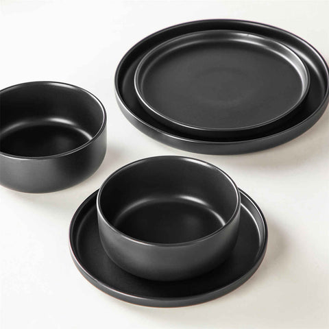 A matte black 24-piece stoneware dinnerware set from the Playa collection by vancasso - adding a modern flair with plates and bowls for 6 people.